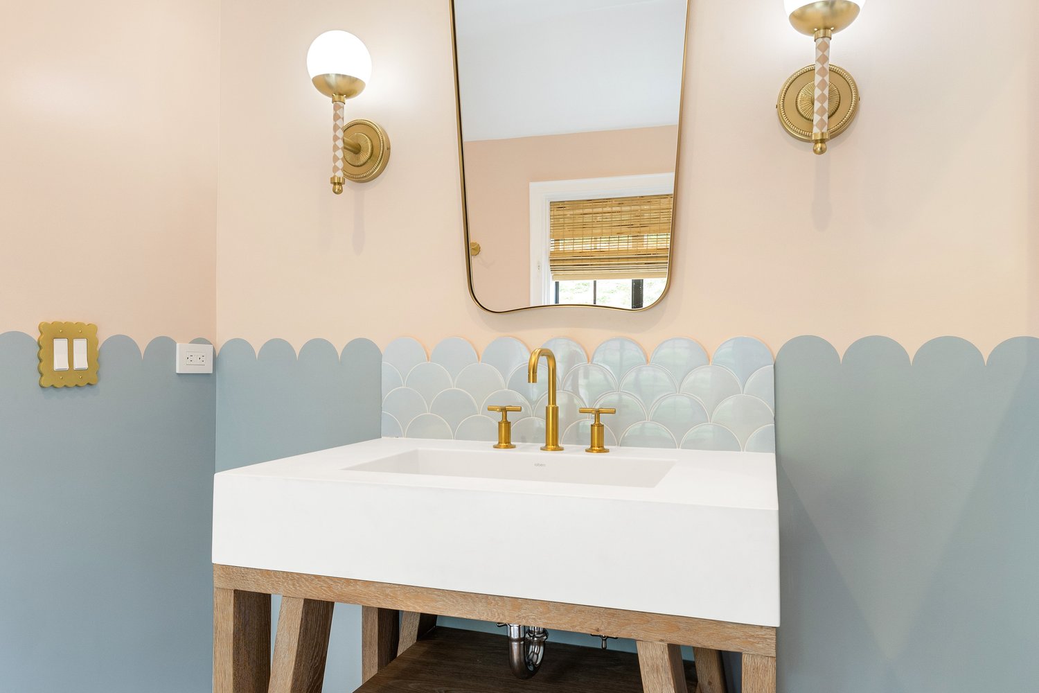 Fish-scale wall tile and brass vanity fixtures
